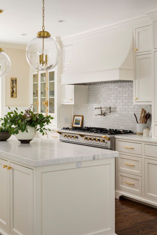 a large kitchen with white cabinets and marble counter tops, along with an island in the middle