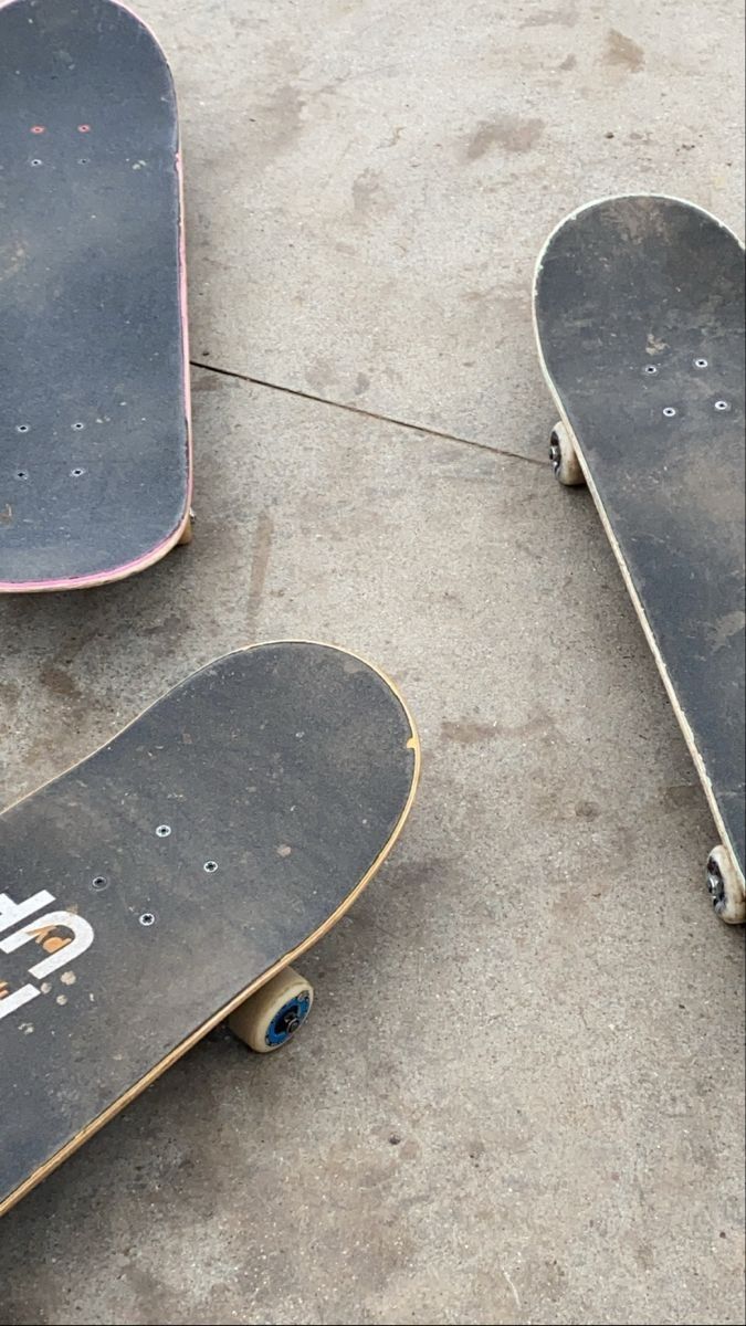 two skateboards sitting on the ground next to each other