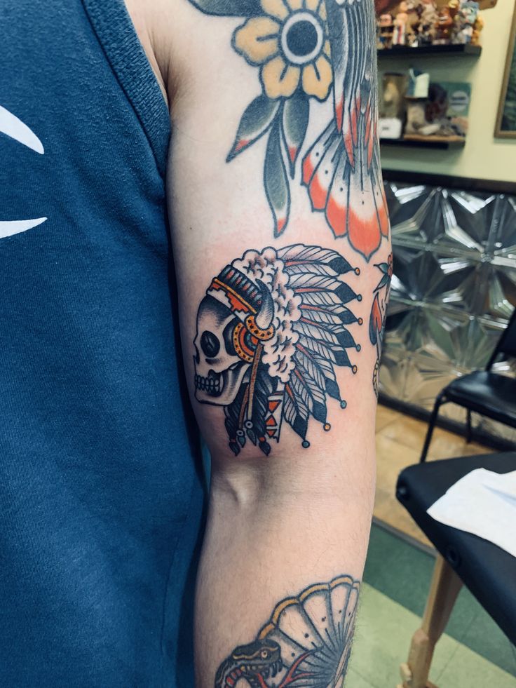 a man with a tattoo on his arm and headdress is standing in a store