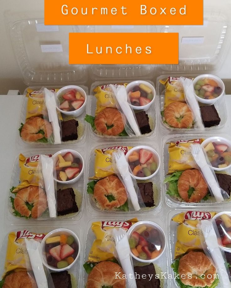 lunch boxes filled with gourmet boxed lunches, including croissants and fruit