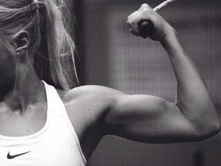 a black and white photo of a woman flexing her muscles