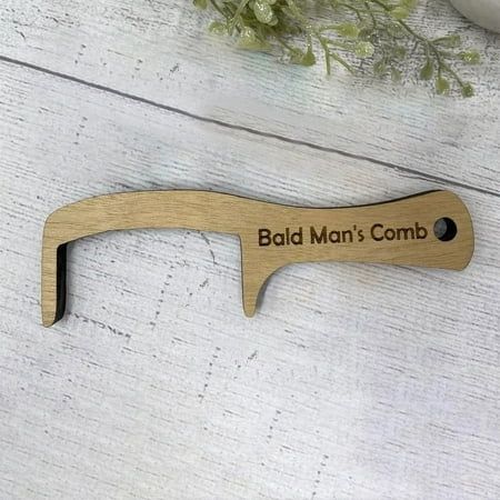 a wooden bottle opener with the words bald man's comb on it next to some flowers