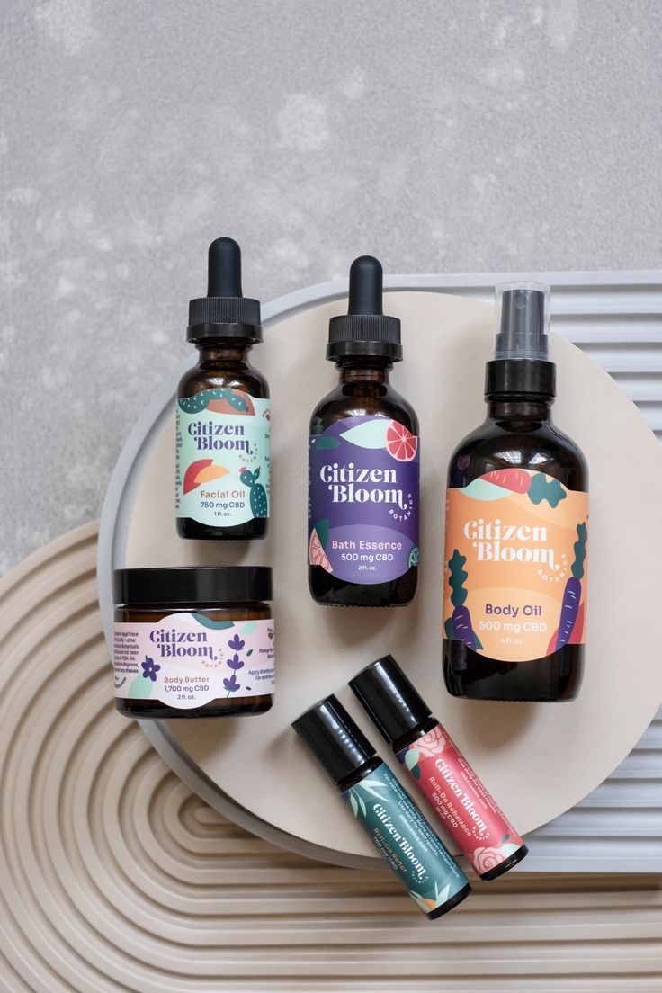 three bottles of essential oils on a plate with some other items in the back ground