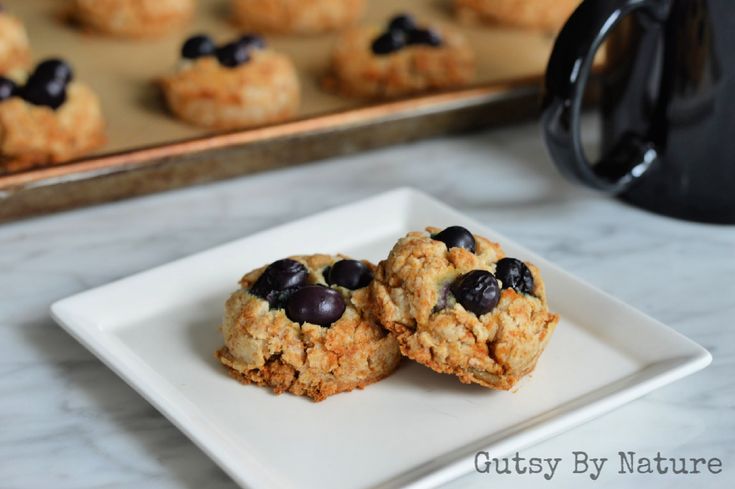 two blueberry oatmeal cookies on a plate next to a muffin tin