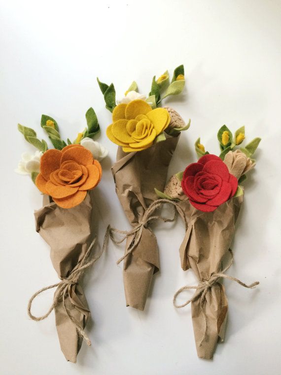 three paper flowers are tied together with twine to make them look like they have been made out of brown paper