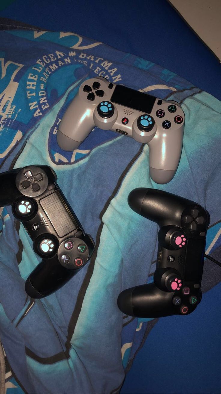 two video game controllers sitting on top of a blanket