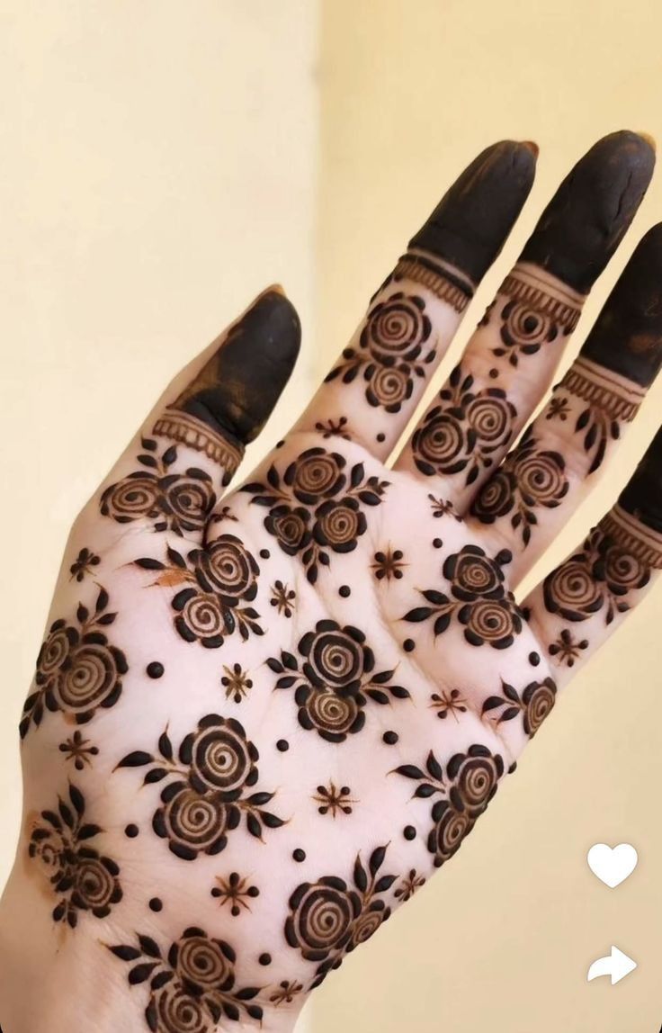 the hand is decorated with black and white henna designs on it's palm