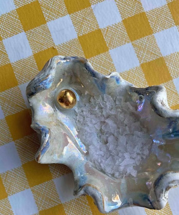 a white bowl filled with rice on top of a yellow and white checkered table cloth