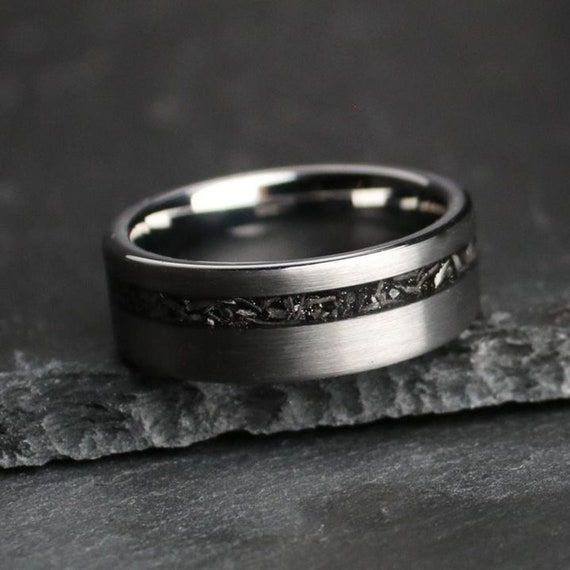 a wedding band that has been made with white gold and black diamond inlays