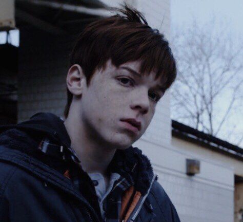 a young man standing in front of a building