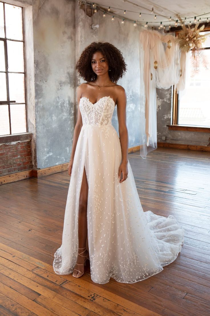 a woman in a white dress standing on a wooden floor