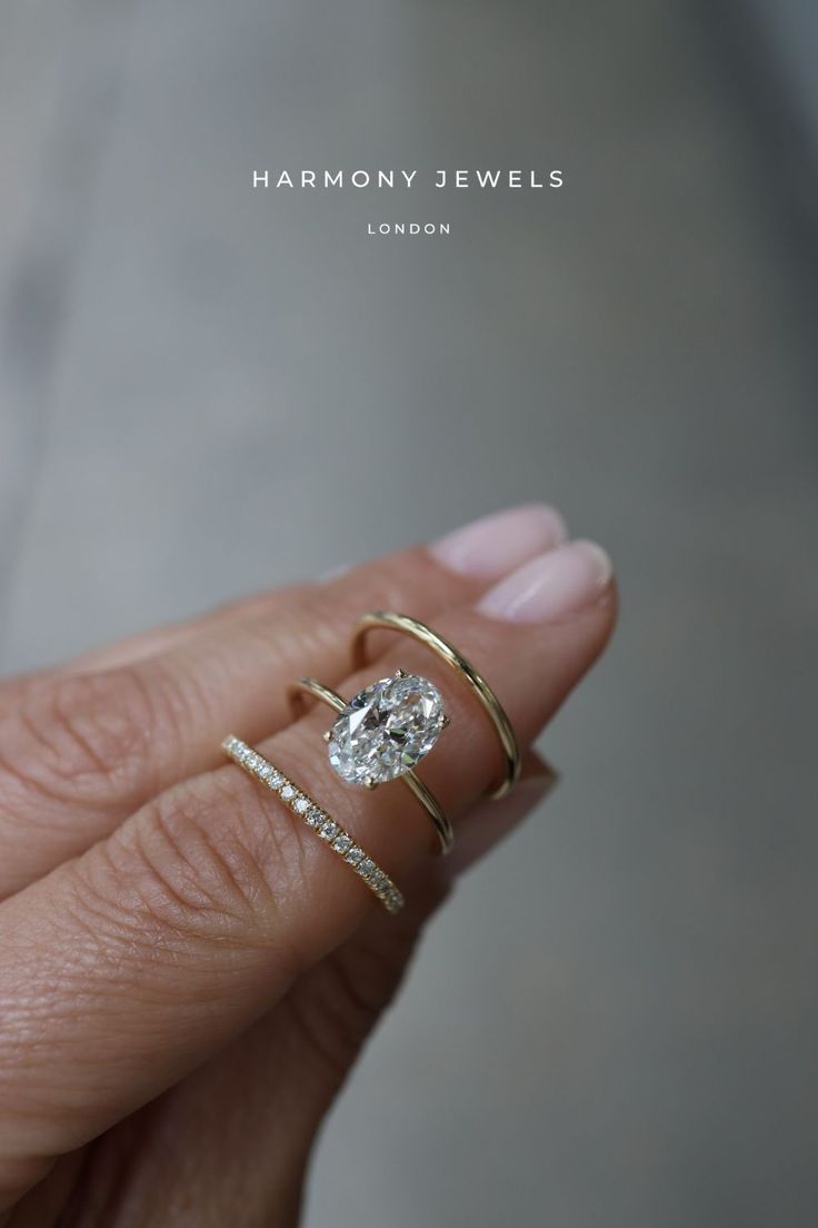 a woman's hand with two rings and a diamond ring on top of her finger