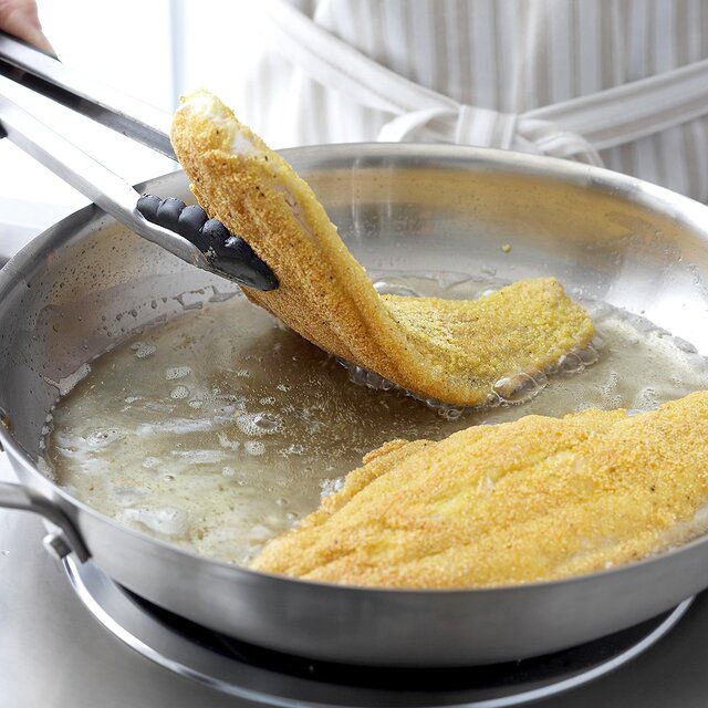 two fried fish being cooked in a frying pan