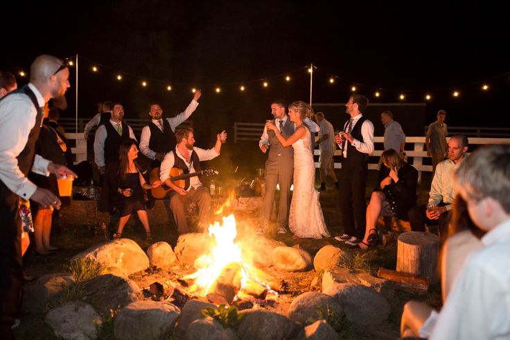 a group of people standing around a fire pit