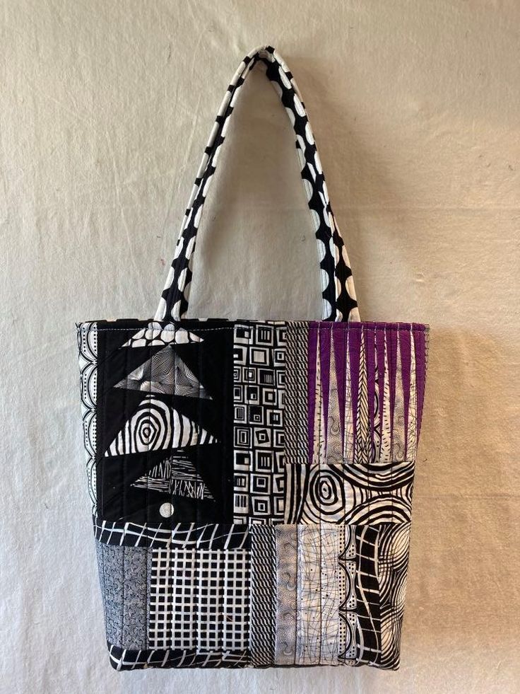 a black and white tote bag hanging on a wall