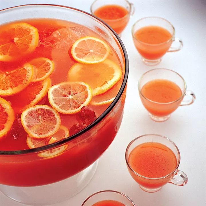 a pitcher filled with orange juice surrounded by glasses