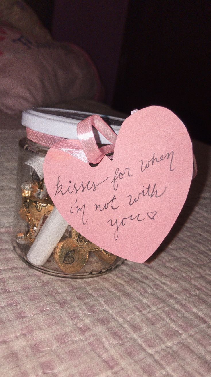 a jar filled with lots of coins and a heart shaped sign on the lid that says kisses for when i'm not in love you