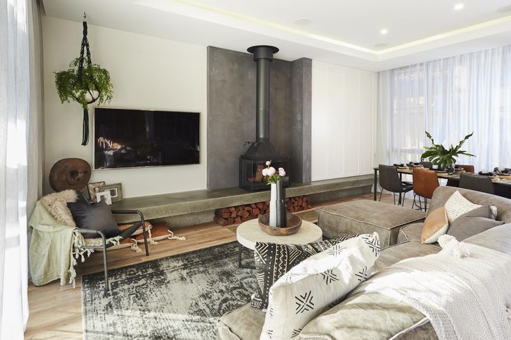 a living room filled with furniture and a flat screen tv mounted on the wall above a fireplace