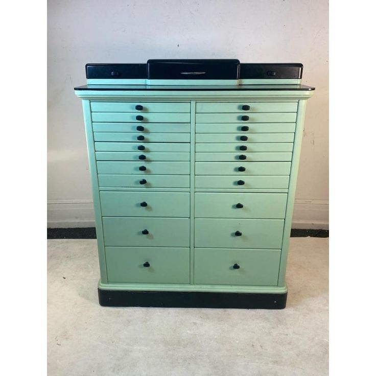 a large green cabinet with many drawers