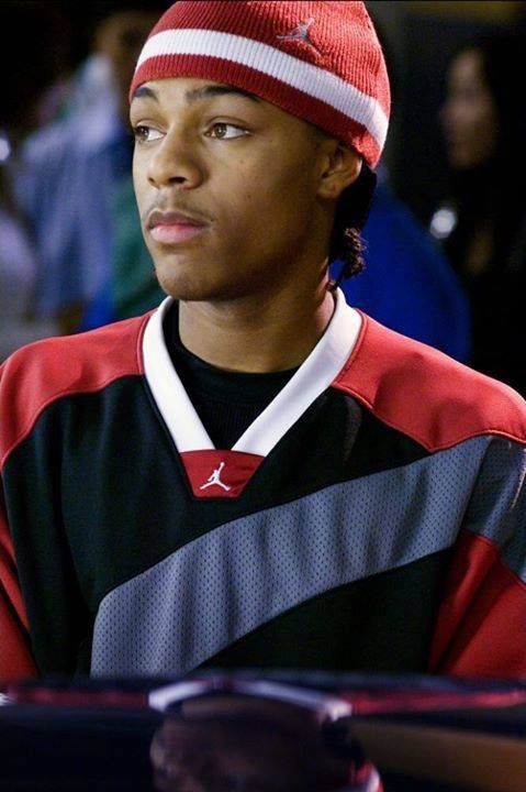 a young man wearing a red and black shirt with a beanie on his head