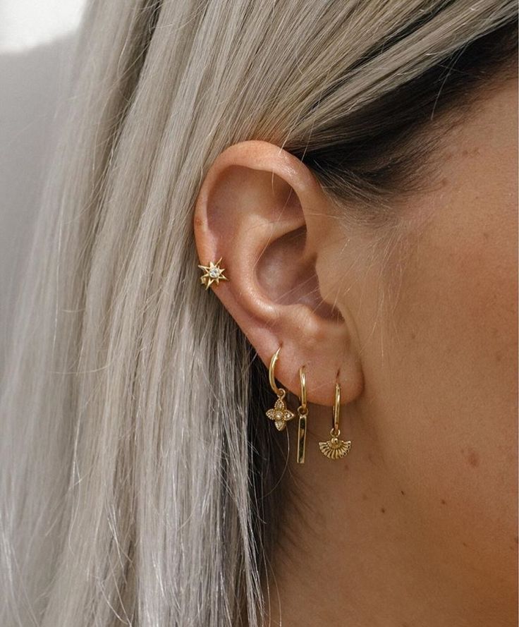 a woman with blonde hair wearing gold earrings