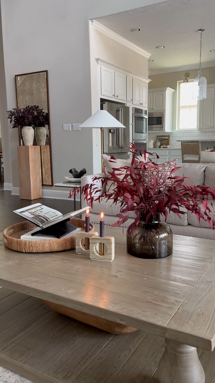 a living room filled with furniture and a wooden table topped with a vase full of flowers