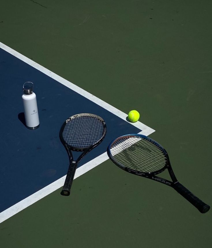 a tennis racket and ball on the court