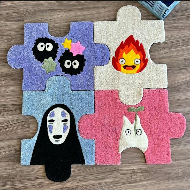 four pieces of colorful rug with faces on them sitting on a wooden floor next to a book