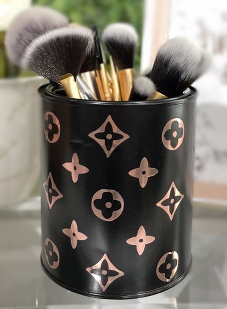 makeup brushes in a black holder on a table