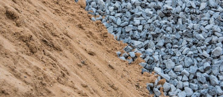 the blue rocks are next to each other on the sand and dirt road side by side