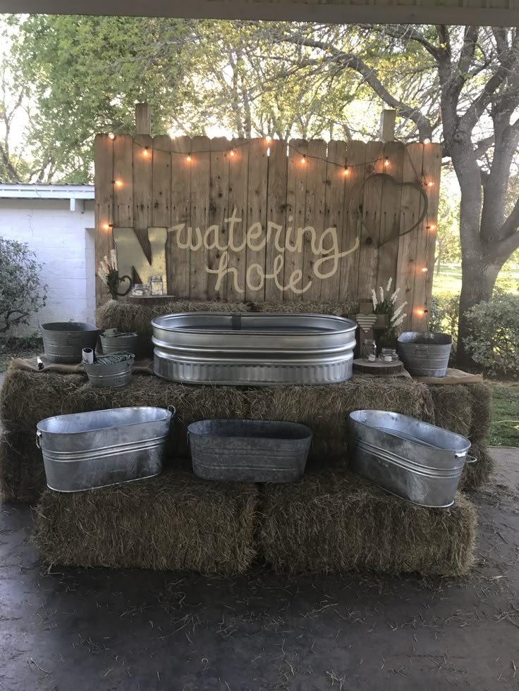 hay bales are stacked on top of each other in front of a wooden sign