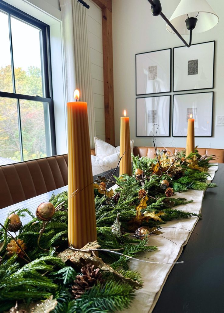 the table is set with candles and greenery on it, along with other decorations