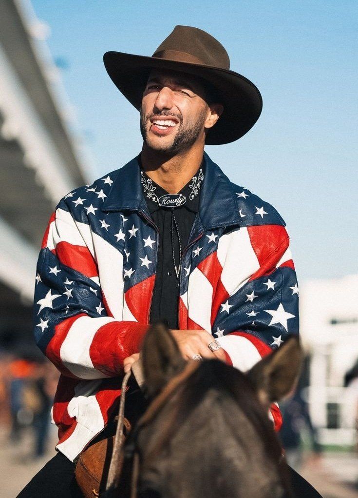 a man wearing an american flag jacket riding a horse