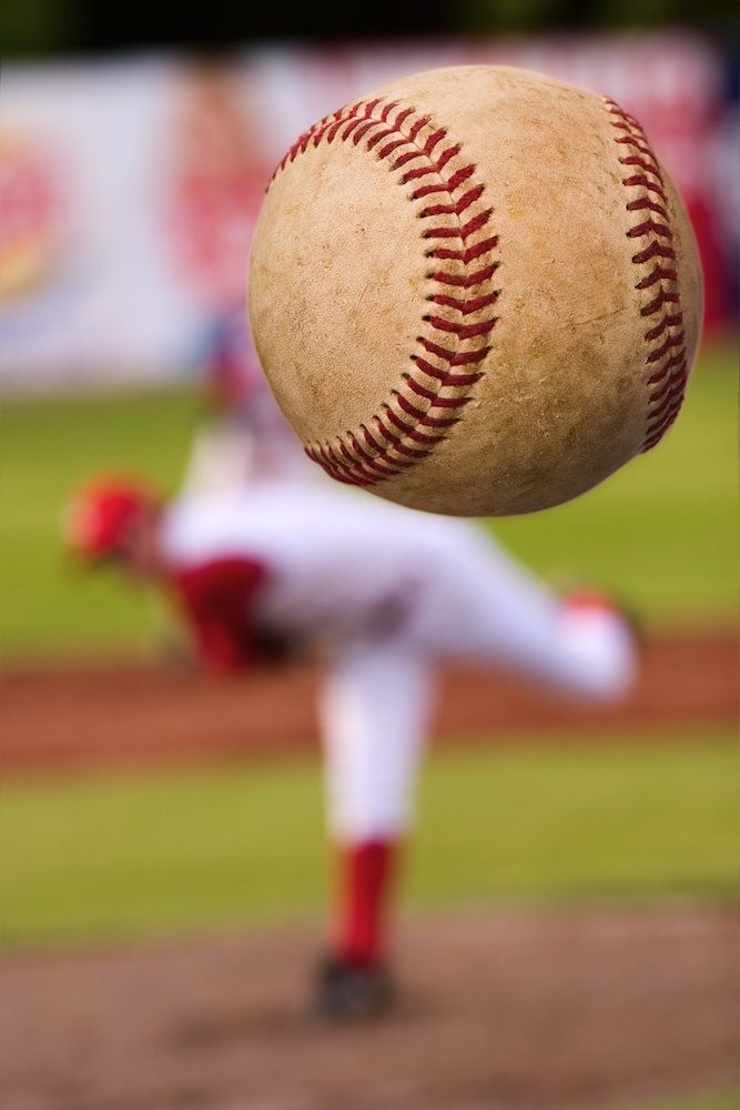 a baseball player throwing a ball in the air