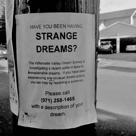 a sign posted on a telephone pole that says, have you been having strange dreams?