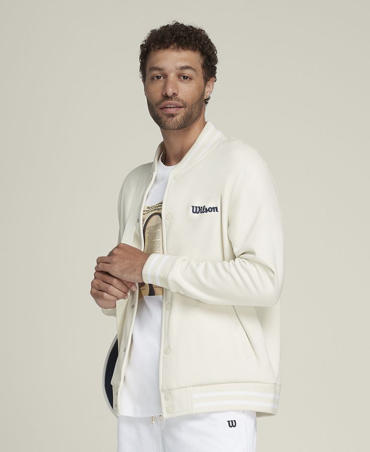 Suit up in timeless sport style. An easy layer to snap over a polo or tee, the Hudson Bomber Jacket brings a touch of luxury to the court. It's made of premium tricot fabric that feels comfortably breathable and wonderfully soft against your skin. Wilson branding accents this bomber, nodding to a hundred-year legacy on the court. | Wilson Men's Hudson Bomber Jacket Sporty Spring Sweatshirt With Logo Detail, Sporty Spring Sweatshirt With Logo, Classic Fall Outerwear With Logo Detail, Sporty Winter Outerwear With Logo Detail, Classic Fall Outerwear With Logo, Cotton Outerwear With Logo And Crew Neck, White Sporty Outerwear With Logo Detail, Sporty White Outerwear With Logo Detail, Casual Varsity Jacket With Logo And Baseball Collar