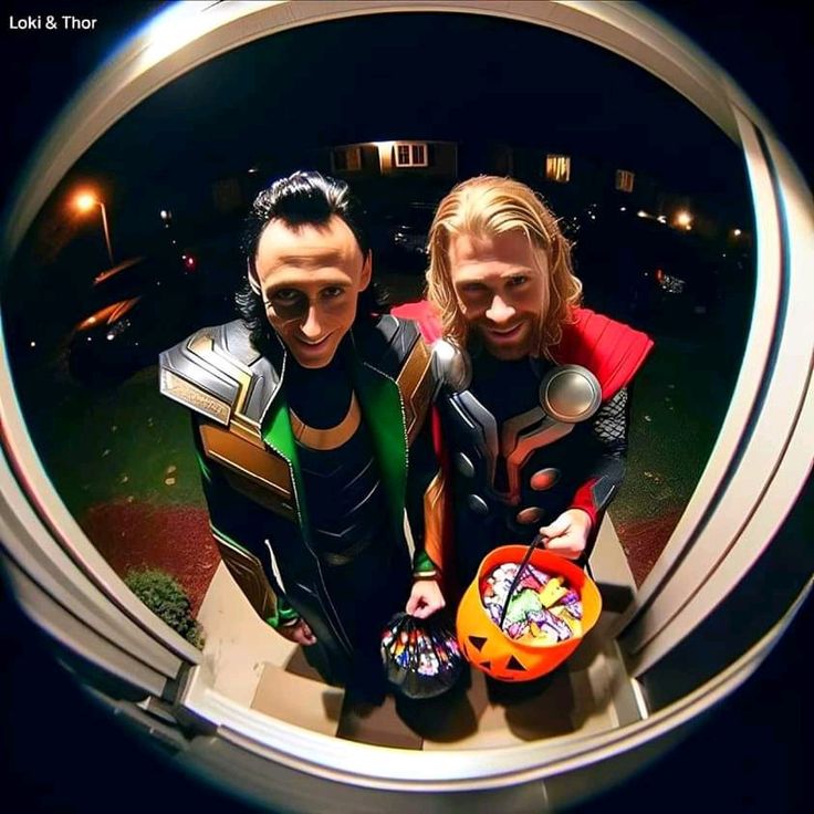 two people dressed as superheros are standing in front of a round window looking at the camera