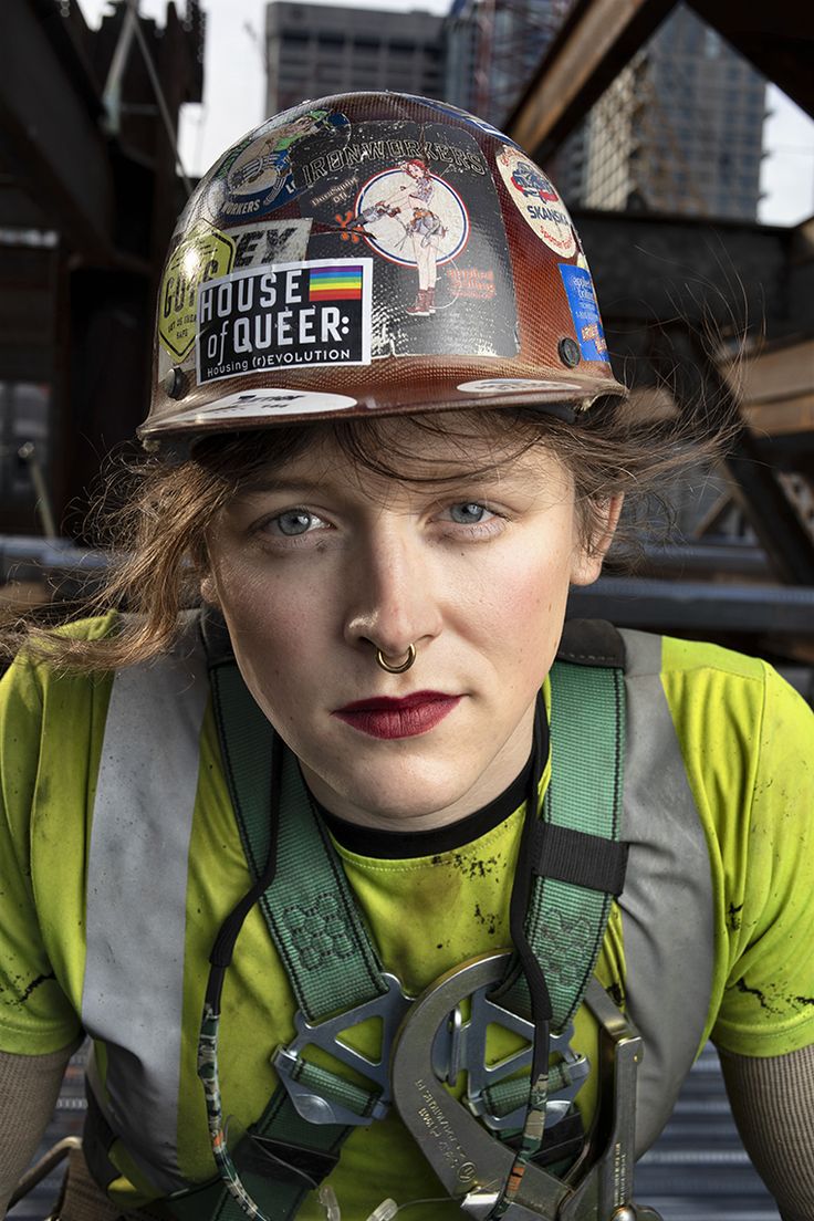 a woman wearing a hard hat and overalls