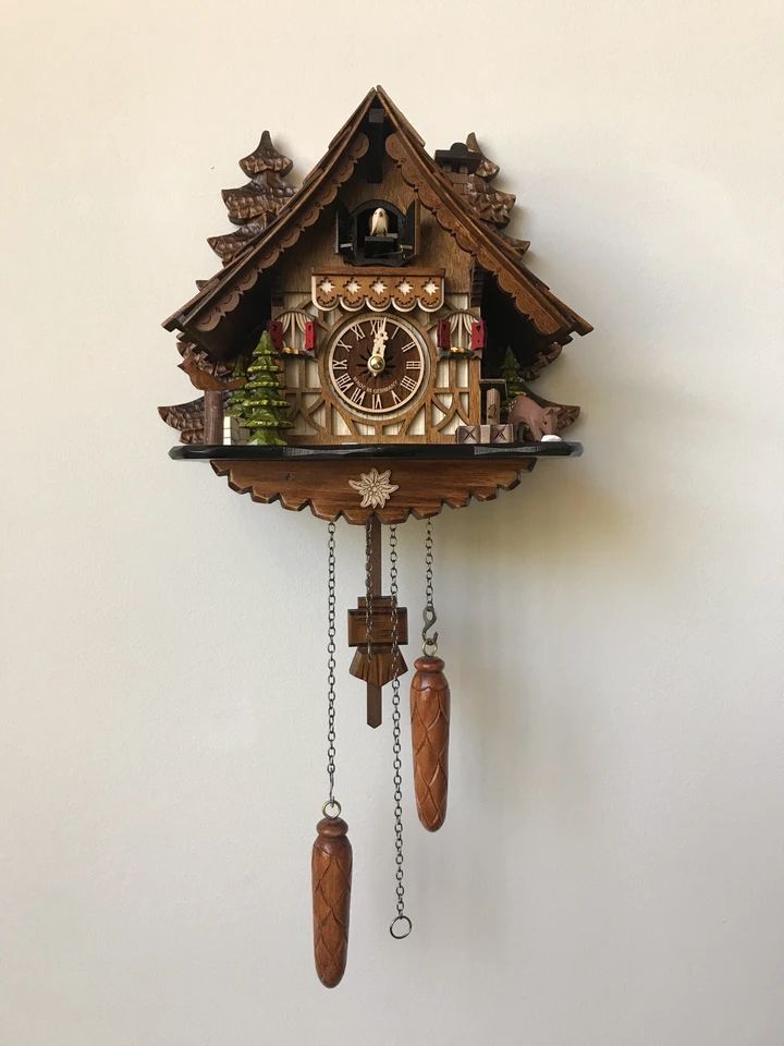 a wooden cuckoo clock on a white wall