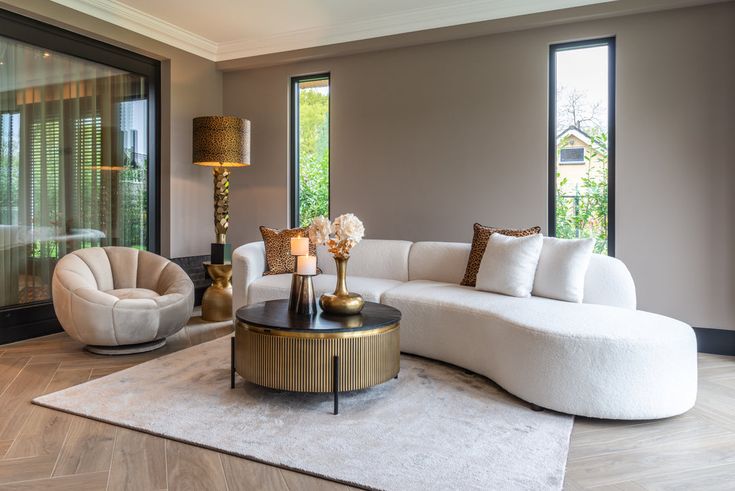 a living room filled with white furniture and lots of window sill space in front of it