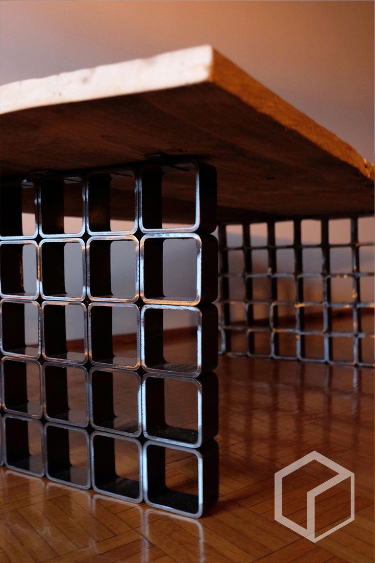 a table made out of metal pipes sitting on top of a hard wood floor