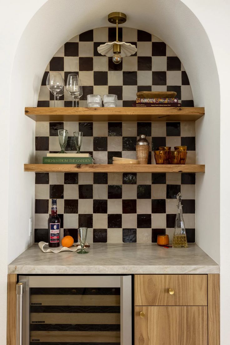 an oven and counter in a kitchen with black and white checkerboard tiles on the wall