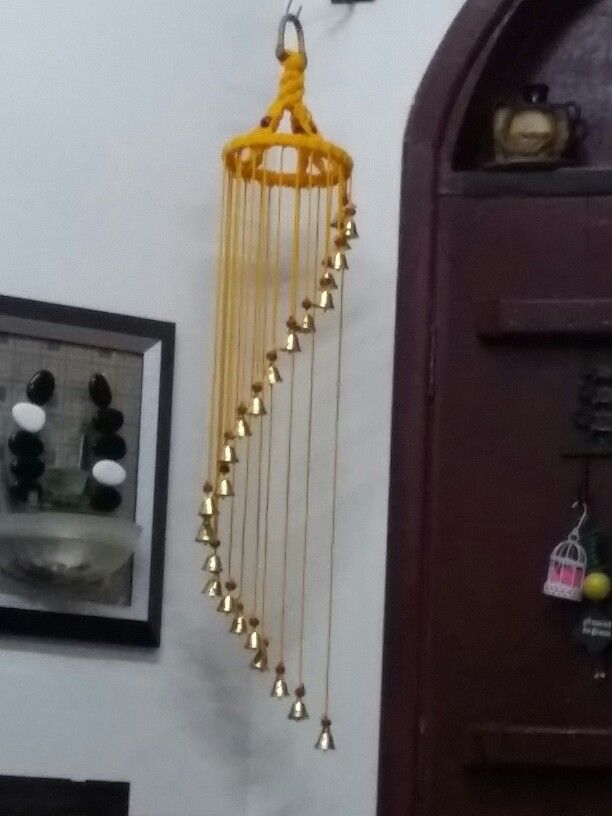 there is a yellow wind chime hanging from the wall