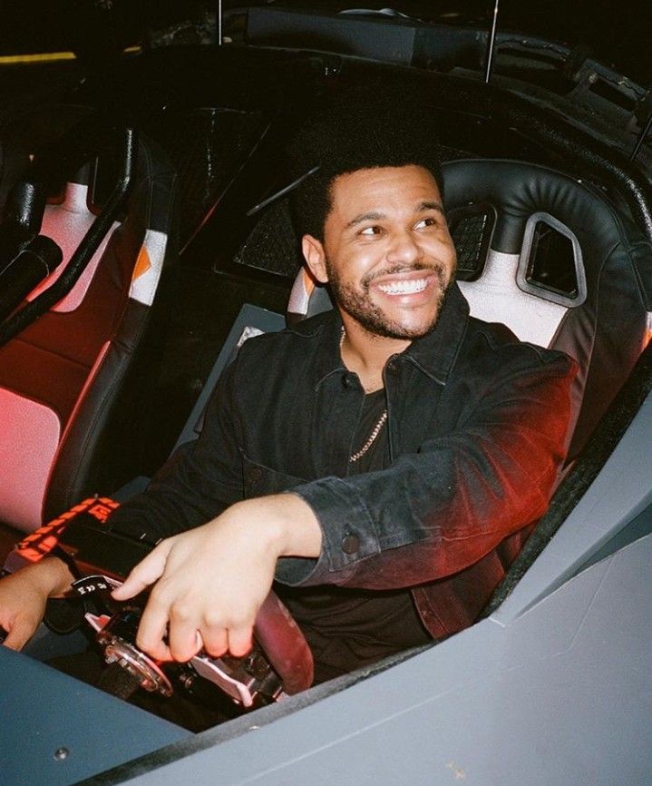 a man sitting in the driver's seat of a car smiling at the camera