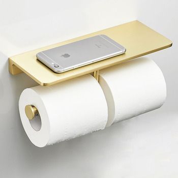 a cell phone is sitting on top of two rolls of toilet paper that are attached to the wall