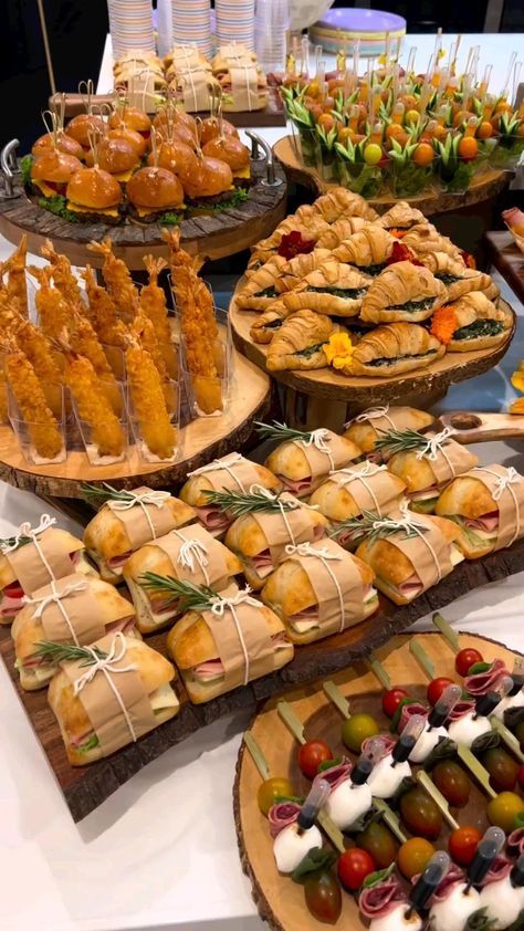 a table topped with lots of different types of food on wooden trays next to each other