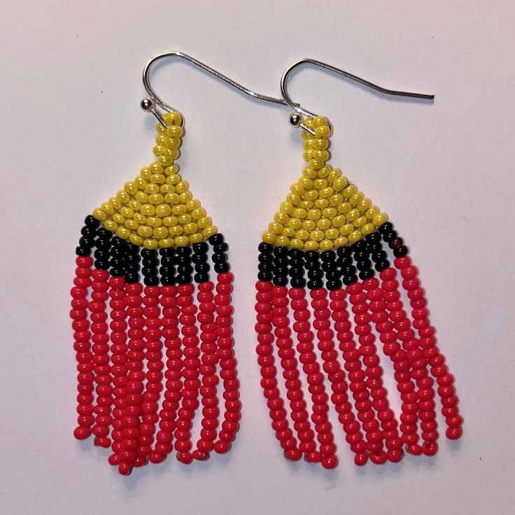 These beaded earrings will bring a pop or color to any outfit. They are hand woven with three colors throughout. Due to the light weight, this move with your movement (without a tickle). Red Handwoven Beaded Earrings For Festival, Adjustable Red Handwoven Earrings, Yellow Handwoven Earrings For Festival, Yellow Handwoven Festival Earrings, Adjustable Multicolor Woven Beaded Earrings, Multicolor Woven Adjustable Beaded Earrings, Handwoven Yellow Beaded Earrings With Round Beads, Yellow Handwoven Beaded Earrings With Round Beads, Adjustable Handwoven Beaded Drop Earrings