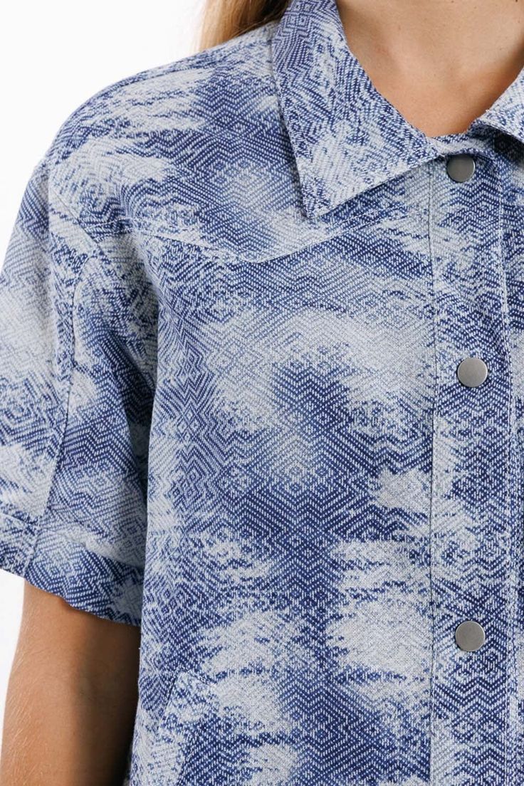 Elevate your spring and summer wardrobe with our Tie Dye Blue Button Up Polo Shirt, a versatile and stylish piece that exudes laid-back charm. Crafted from 100% cotton, this shirt offers both comfort and breathability, making it perfect for warm-weather days.  The tie-dye print in shades of blue adds a playful and trendy touch to this polo shirt, bringing a pop of color to your ensemble. Whether you're heading to a casual outing with friends or enjoying a day in the sun, this shirt is sure to make a statement.  Featuring a classic polo collar and short sleeves, this shirt offers a standard fit that's both comfortable and flattering. The button detail and functional side pockets add a touch of functionality and style, making this shirt as practical as it is fashionable.  Pair this button-up Blue Shirt With Placket And Shirttail Hem, Blue Shirt With Rolled Sleeves For Daywear, Blue Cotton Collared Shirt, Blue Cotton Shirt With Collared Neckline, Blue Collared Blouse For Summer, Blue Summer Blouse With Collared Neckline, Blue Collared Neckline Summer Blouse, Blue Summer Shirt With Placket, Blue Short Sleeve Shirt For Spring Beach