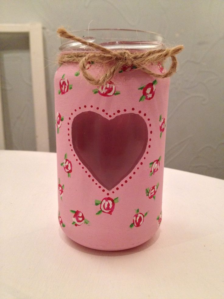 a pink mason jar with a heart cutout on the front and rope around it