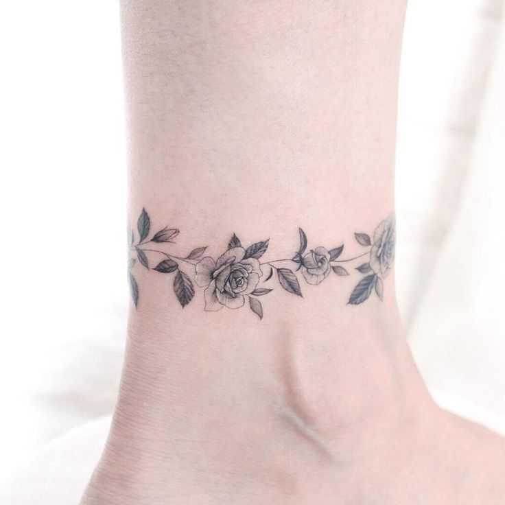 a woman's foot with a rose tattoo on the side of her ankle,